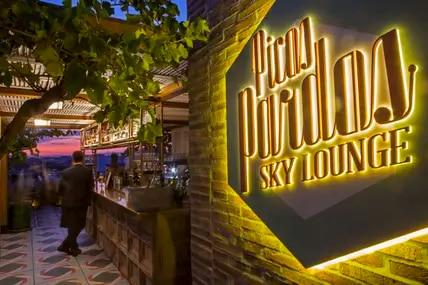 Die Rooftop Bar des Bless Hotel in Madrid lädt abends zum Cocktail ein. Ein Neonschild leuchtet den Weg. 